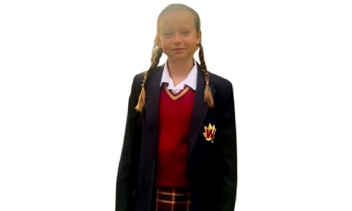 Pupil in navy blue and red school uniform